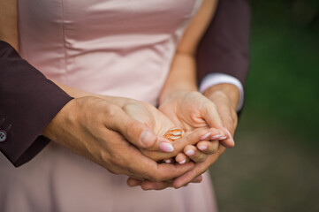 Obraz na płótnie Canvas Gold wedding rings on the palms of the bride and groom 2554.