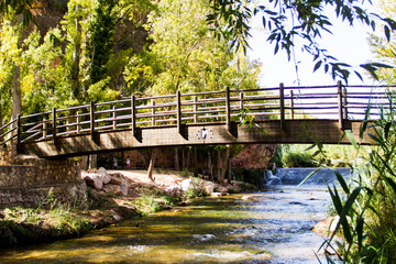 wooden bridge over river in field