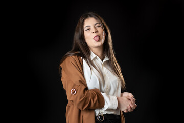 chica joven haciendo burlas sobre fondo negro