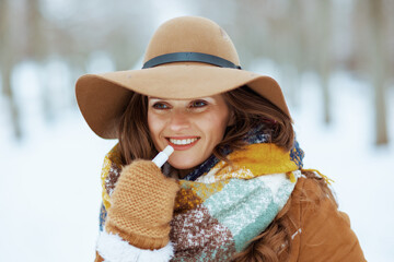 happy stylish woman outside in city park in winter