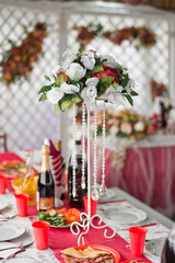 Bouquet on a stand among the wedding table 2815.