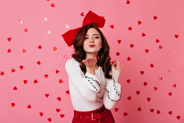 Fototapeta premium Refined girl sending air kiss. Studio photo of romantic lady isolated on pink.