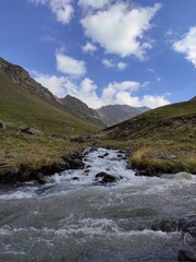 Fast River flows among the mountains, cloudy blue sky, morning shot in Azerbaijan