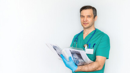 Attractive male doctor in a blue suit and a medical history of the patient with x-rays close-up on a white background. Banner with a caucasian doctor radiologist for advertising medical services.