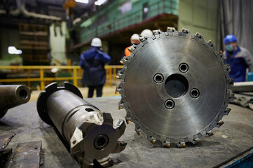A durable high-quality cutter with a diameter of 315 mm for metal rolling of high-strength carbide alloys lies on the workbench of a turner-milling machine, steel, molybdenum, hard cutters