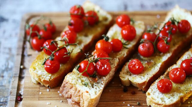 Bruschetta with olive oil and cherry tomatoes. Delicious ciabatta with baked tomatoes.