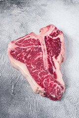 Raw T-bone or porterhouse Steak on kitchen table. White background. Top view