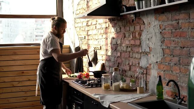 Caucasian male shef enjoying weekend time for cooking at own home kitchen cut fresh vegetables at counter top, professional man preparing lunch meal for eating
