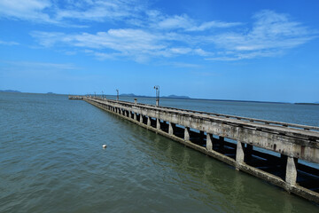 concrete jetty into the sea on blue sky background