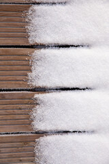 Wooden floor board covered with snow. Garden in winter. 