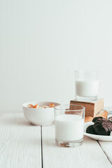 Milk in a glass, marshmallows and crackers on a white background. Side view vertical orientation. Tinted in vintage style.