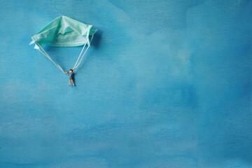 COVID-19 concept with parachute mask and blue background