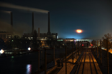 Beautiful shot of the bright moon in the night sky over a train station