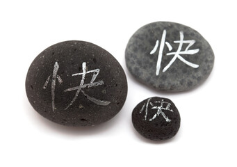 Obraz na płótnie Canvas Chinese character kuai, meaning happy written on a volcanic rock pebble 