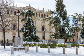 san diego square in the city of alcala de henares snow covered on a sunny day with facade of cisneriana university in the background
