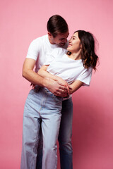 Fototapeta premium young cheerful caucasian couple together having fun on pink background, guy ang girl modern relationship, lifestyle people concept