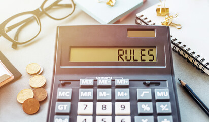 Word RULES written on calculator on office table.