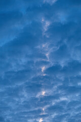 background texture of the sky with thick cloud and light shine through the crack of the cloud
