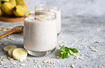 Smoothie with banana and oatmeal for breakfast on a light concrete background. Detox menu.