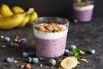 Smoothie with blueberries, yogurt and granola on a dark background. Detox menu. Diet.