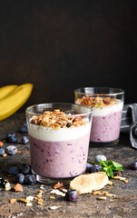 Smoothie with blueberries, yogurt and granola on a dark background. Detox menu. Diet.
