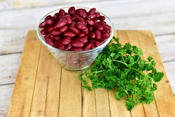 Red Kidney beans in glass bowl with fresh herbs ready for preparing healthy vegan or vegetarian meals. Simple bowl of beans photo concept with copy space