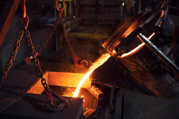 Filling cast with molten iron in foundry. Metallurgy and industry.