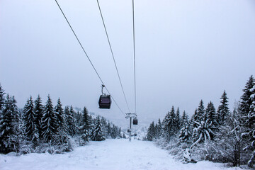 Obraz premium Cable car photographed from Trebevic in winter while it is snowing. Snow in winter on the mountain Trebevic. Sarajevo cable car in nature. Winter and snow.