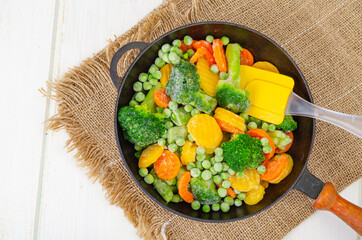 Frozen carrots, broccoli and green peas in frying pan. Studio Photo