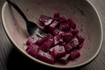 Beetroot salad in a gray deep plate with a black salad fork. 
