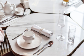 White table setting. Elegant empty plate, cutlery, napkin and cup, for breakfast. Selective Focus