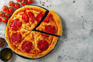 Tasty pepperoni pizza and cooking ingredients tomatoes basil on white concrete background. Top view of hot pepperoni pizza. With copy space for text. Flat lay