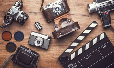 Vintage retro camera with clapboard on wooden background