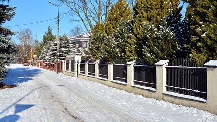 Residential neighborhood in the suburbs during a white snow storm and roads covered in snow. 