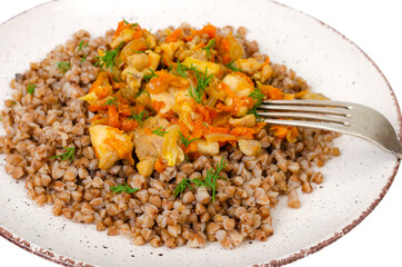 Plate with buckwheat porridge with vegetables and chicken isolated on white background. Studio Photo