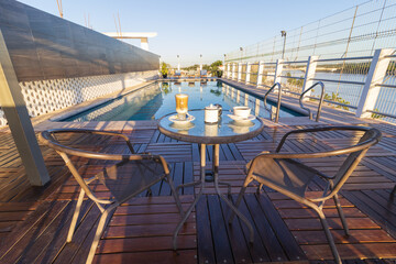 Tomar rico café cerca de la piscina.