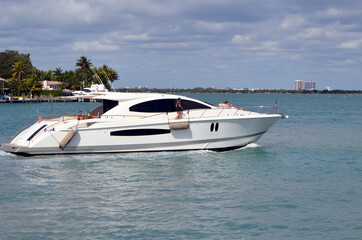 Obraz premium Luxury white motor yacht cruising slowly on Biscayne Bay near Miami Beach,Florida.