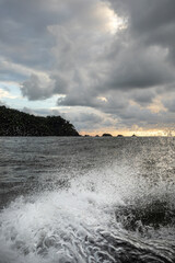 sunset over the sea, shot from a boat, splashing water