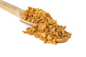 Crispy carmelized fried onion flakes in wooden spoon isolated on white background. Spices and food ingredients.