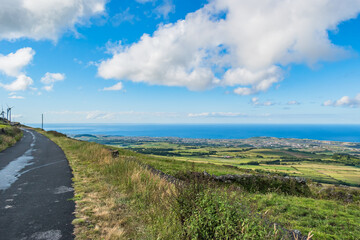 Fototapeta na wymiar Serra do Cume with grass and stone wall with road overlooking the Atlantic Ocean, Terceira - Azores PORTUGAL