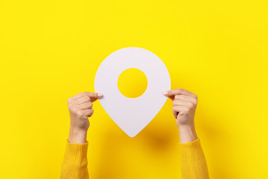 white map pointer 3d pin  in hand over yellow background
