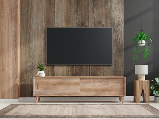 Mockup a TV wall mounted in a dark room with a dark wood wall.