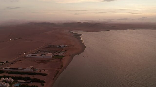 Aerial dolly shot along the coastal line of Paracas Peru, shot in the evening sunlight on a calm day