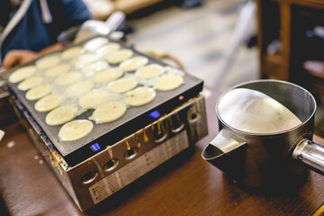 Cooking takoyakis at restaurant in Shinsekai district, Osaka, Japan