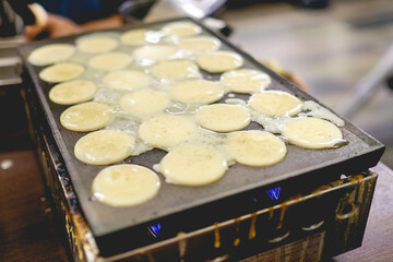 Cooking takoyakis at restaurant in Shinsekai district, Osaka, Japan