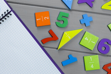 Close up mathematical fractions and notebook on gray background. Creative, fun mathematics banner....