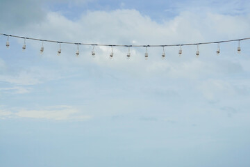 hanging light bulbs wire with blue sky backdrop