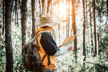 Fototapeta premium Male holding map for check location adventure in forest, Holidays concept