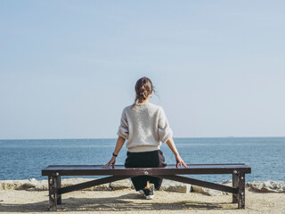 ベンチに座る女性の後ろ姿