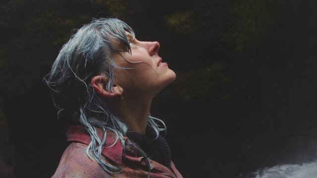 Blue Haired Woman Looking Up To Waterfall